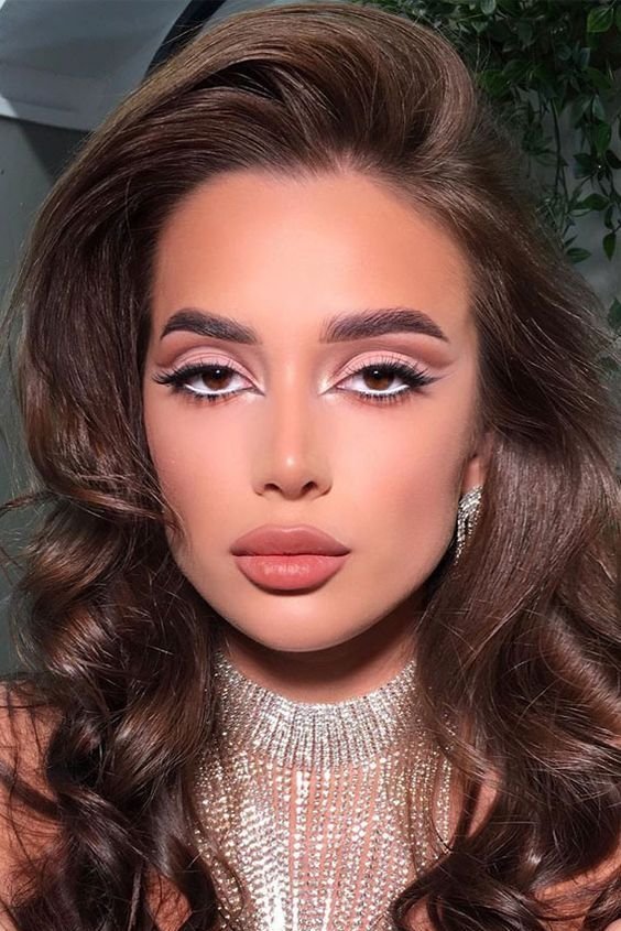 Woman with champagne shimmer eyeshadow and a peachy nude lip