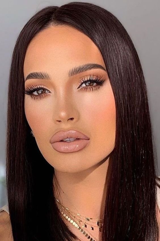 Woman with nude-toned makeup and sleek dark hair