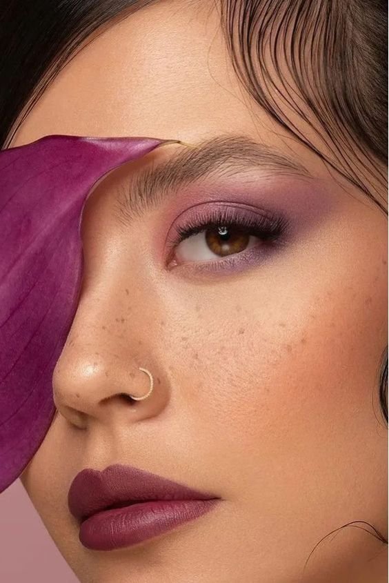 Woman with a deep plum lip and soft plum eye makeup