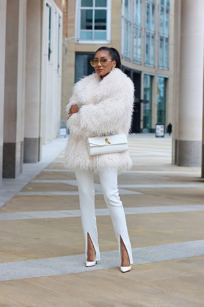 Woman in a white faux fur coat with a white outfit
