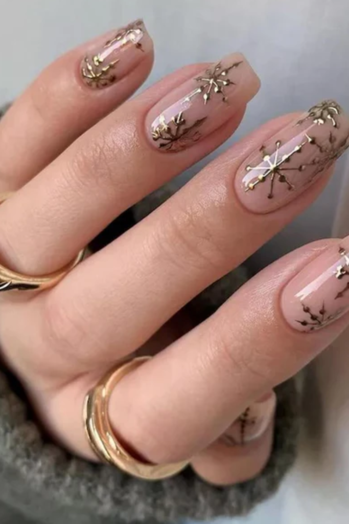 Nude nails with metallic gold snowflakes