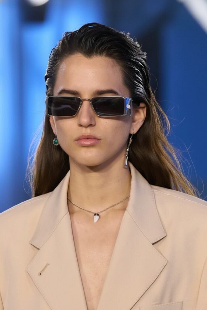 Woman with slicked-back dark hair and sunglasses