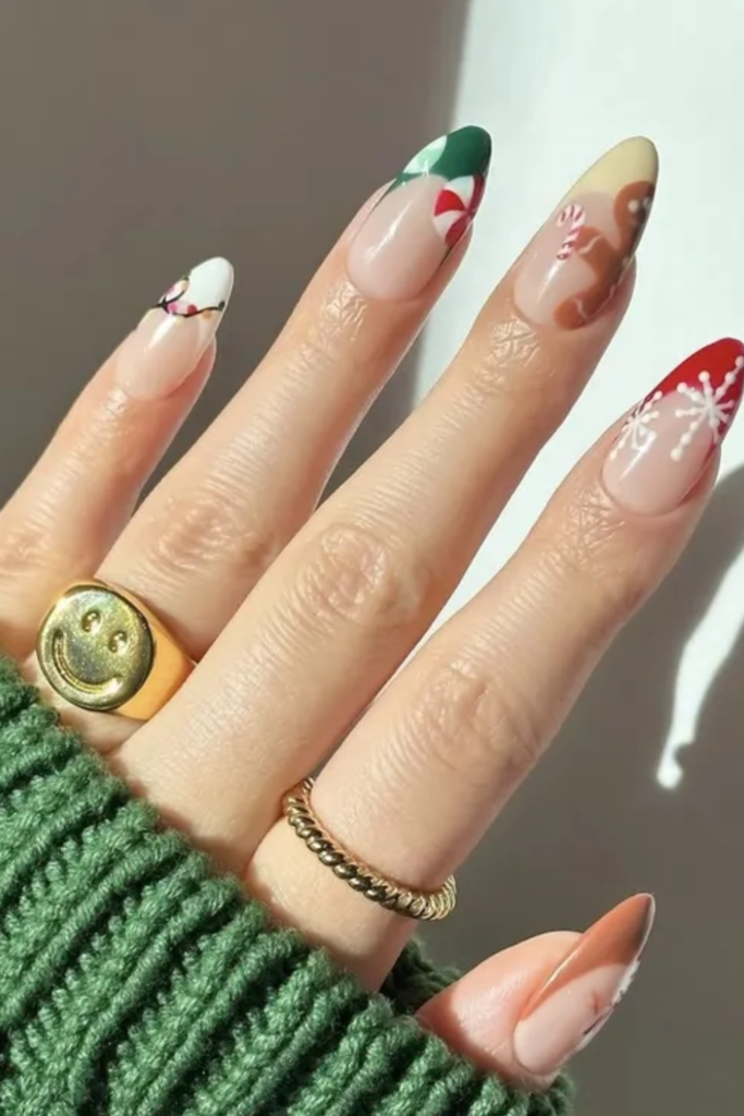 Nude almond nails with a snowflake accent and green and gold tips