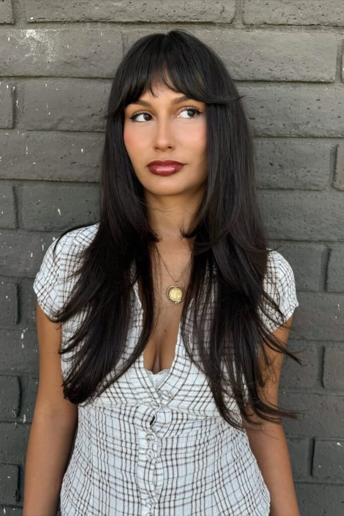Long dark hair with wispy 1960s-style bangs