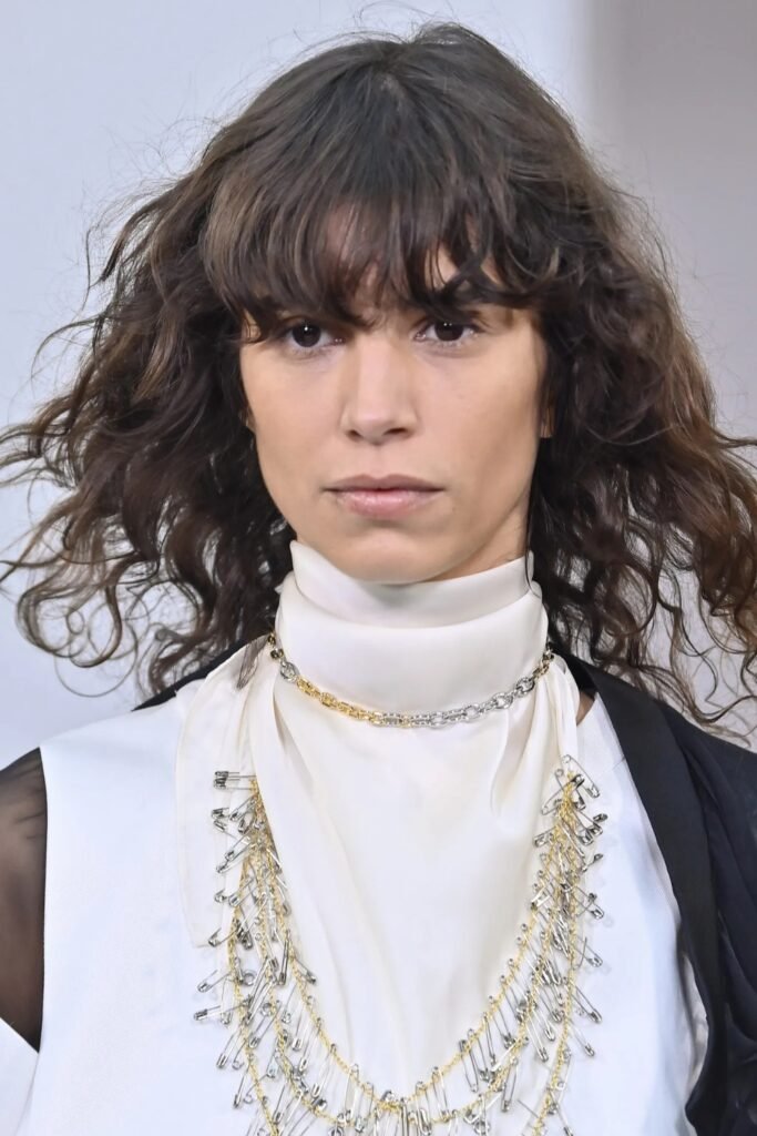 Short choppy dark hair with a heavy textured fringe
