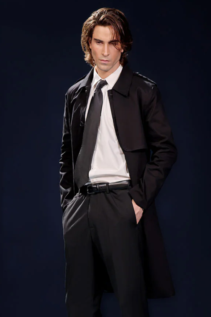 Man in a black trench coat over a white shirt and black tie