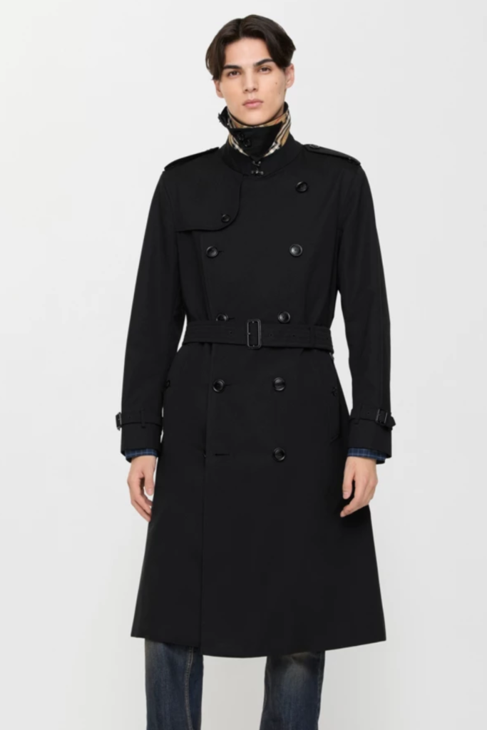 Man in a long black belted trench coat with a high collar
