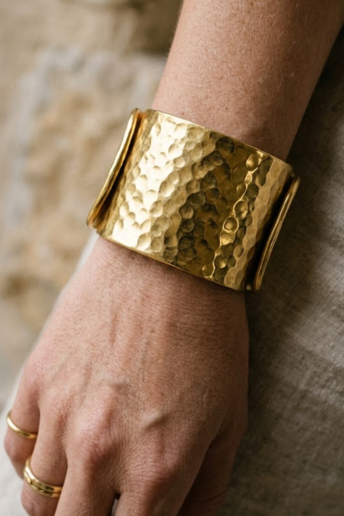 Gold bold hammered wide cuff bracelet on the wrist