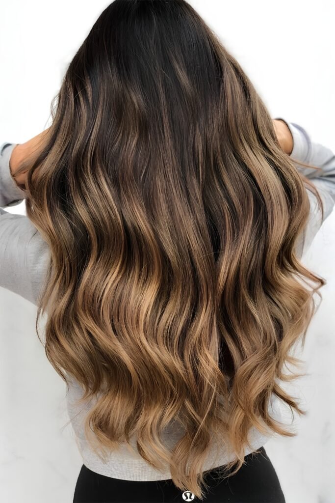 Back view of caramel-streaked waves over a dark root