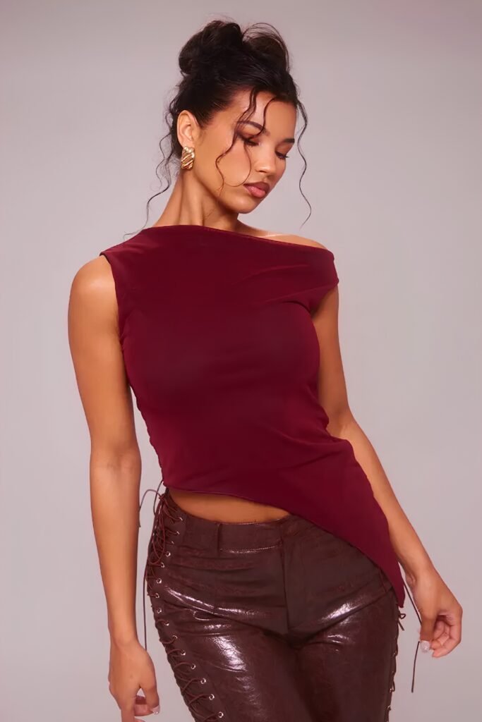 Woman in a cherry red asymmetric top with leather trousers