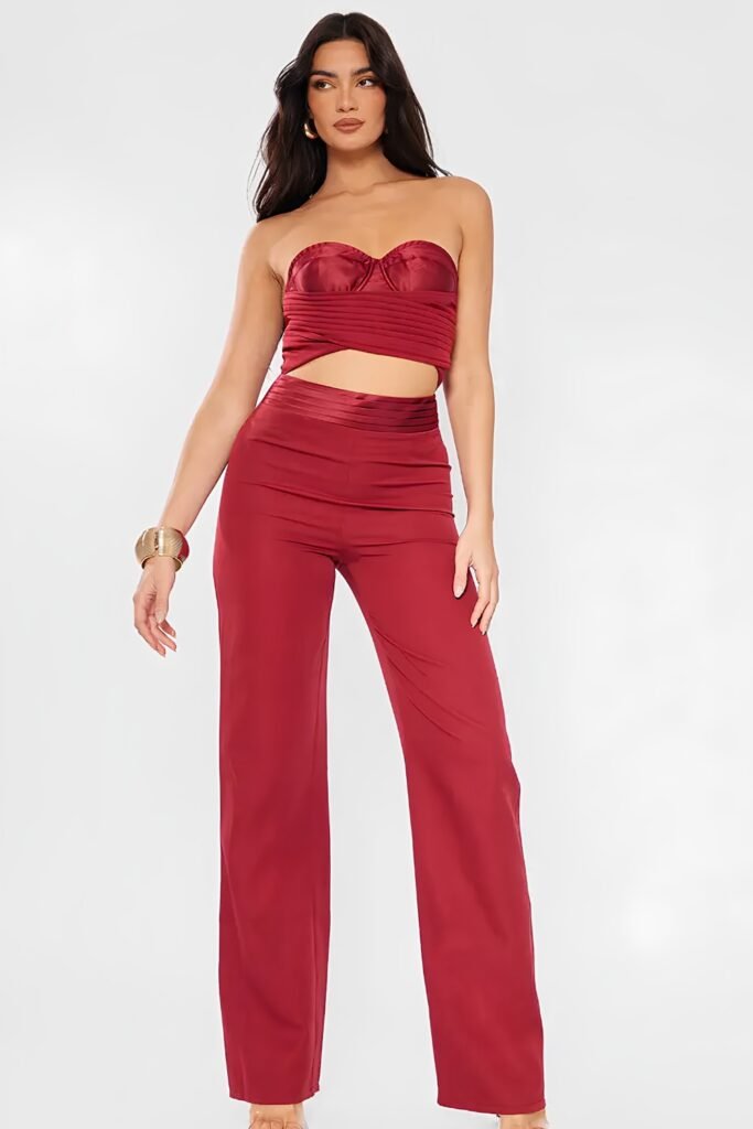 Woman in a cherry red corset top and matching wide-leg trousers