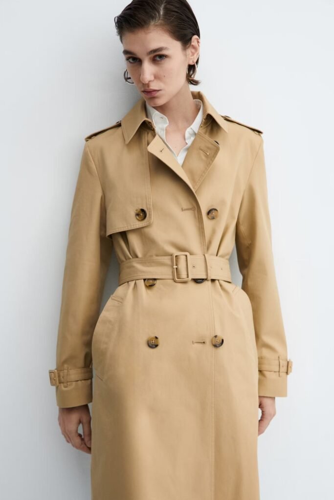 Woman in a classic camel trench coat belted at the waist