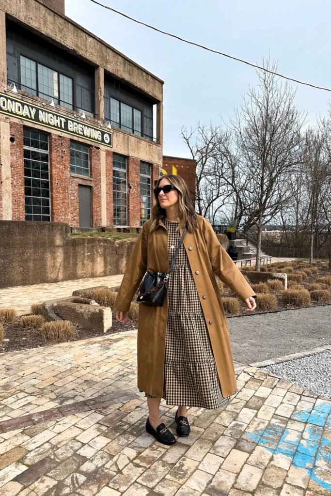 Woman in a long tan trench coat on a brick street