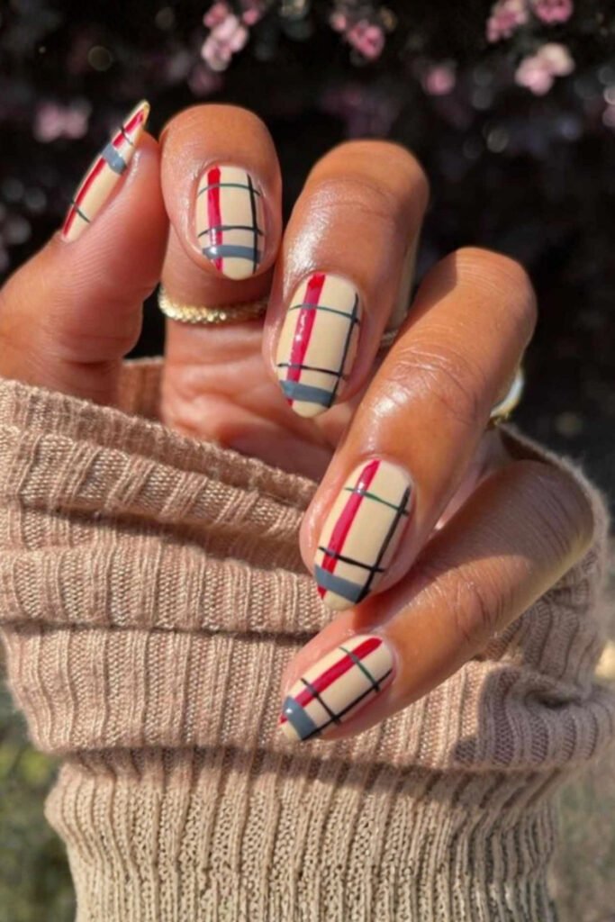Plaid and knit-pattern nails held against a knitted sleeve