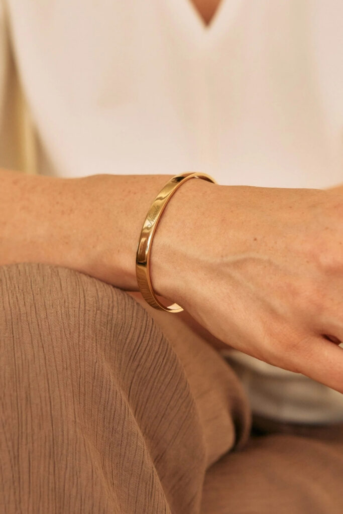 Gold engraved detail cuff bracelet on the wrist