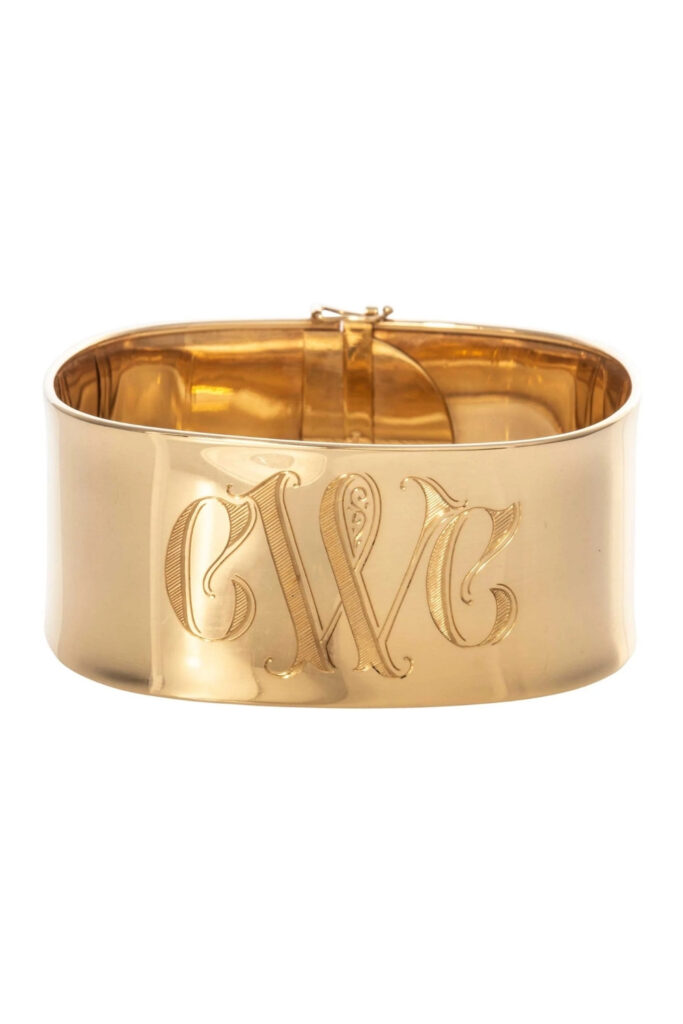 Gold engraved wide band cuff bracelet on the wrist