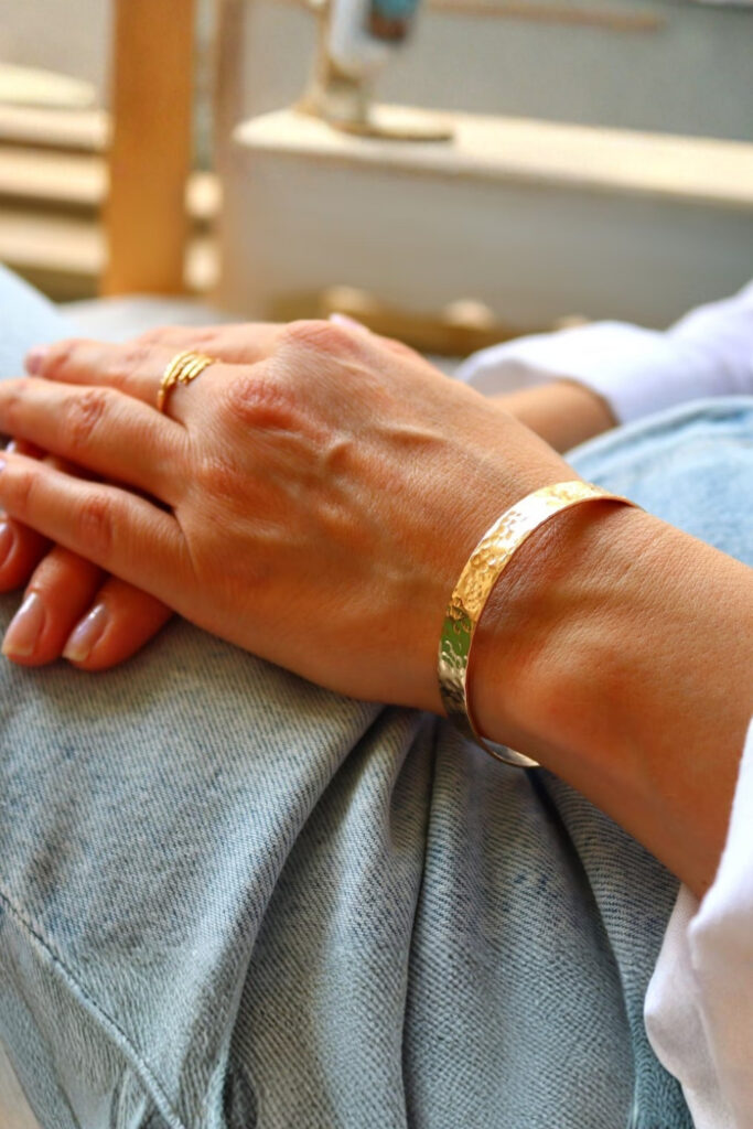 Gold hammered texture cuff bracelet on the wrist