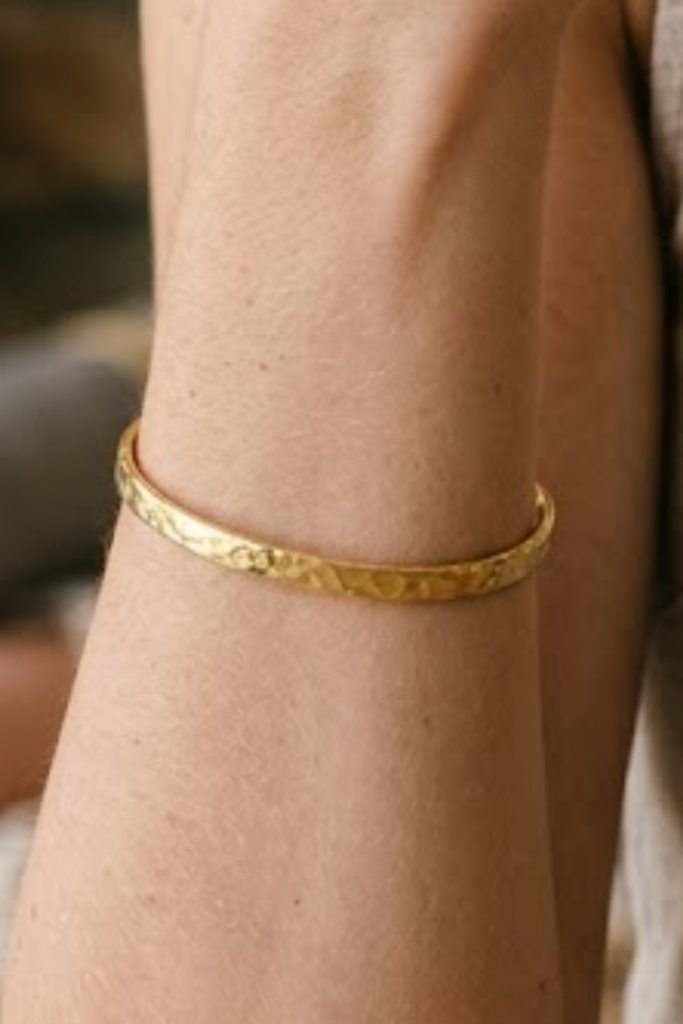 Gold open hammered thin cuff bracelet on the wrist