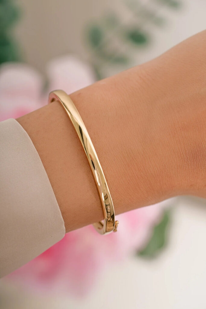 Gold polished open cuff bracelet on the wrist