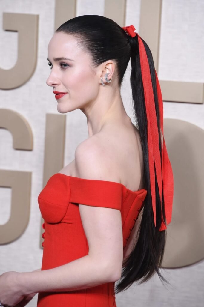 Woman in a red off-shoulder evening dress with a red hair bow