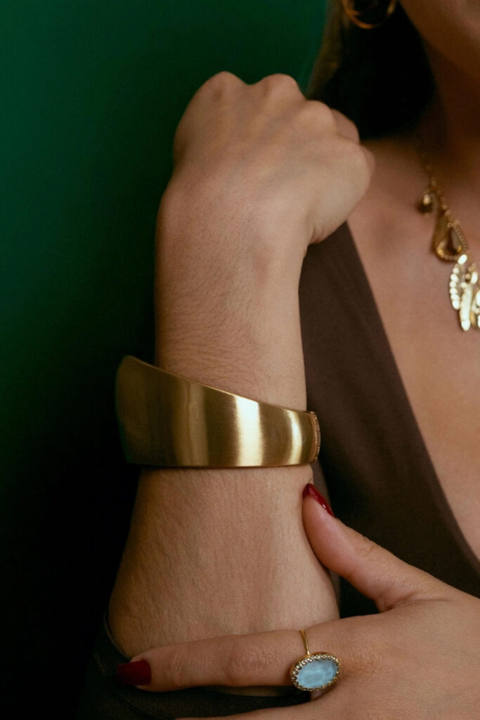 Gold sculptural wide cuff bracelet on the wrist