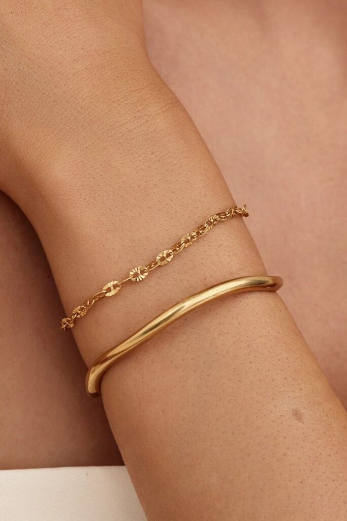 Gold slim sculptural cuff bracelet on the wrist