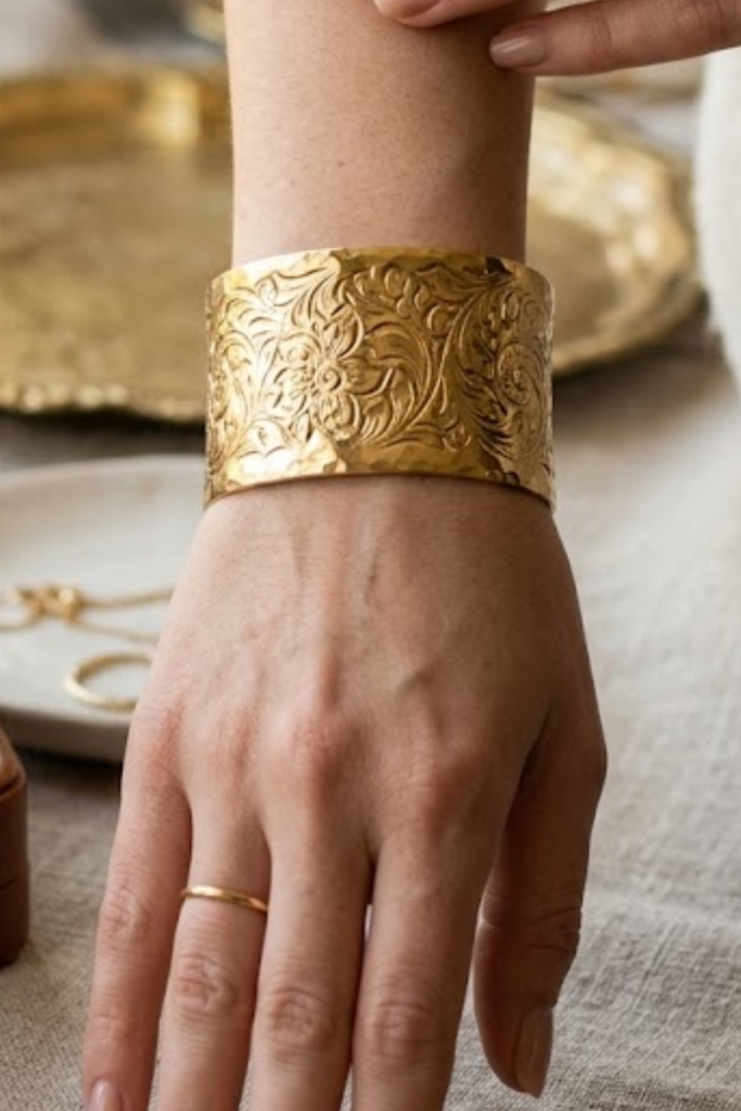 Gold textured engraved cuff bracelet on the wrist