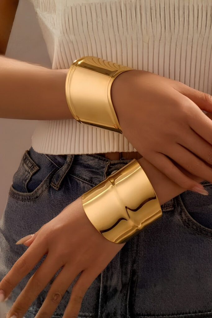 Gold wide polished statement cuff bracelet on the wrist