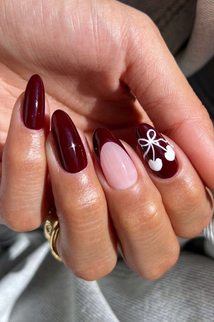 Dark cherry almond nails with one pale pink accent nail