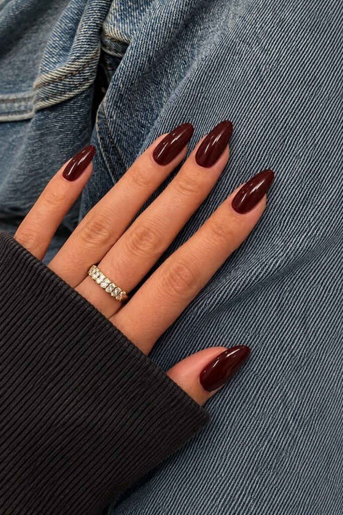 Short cherry mocha nails worn with a denim jacket