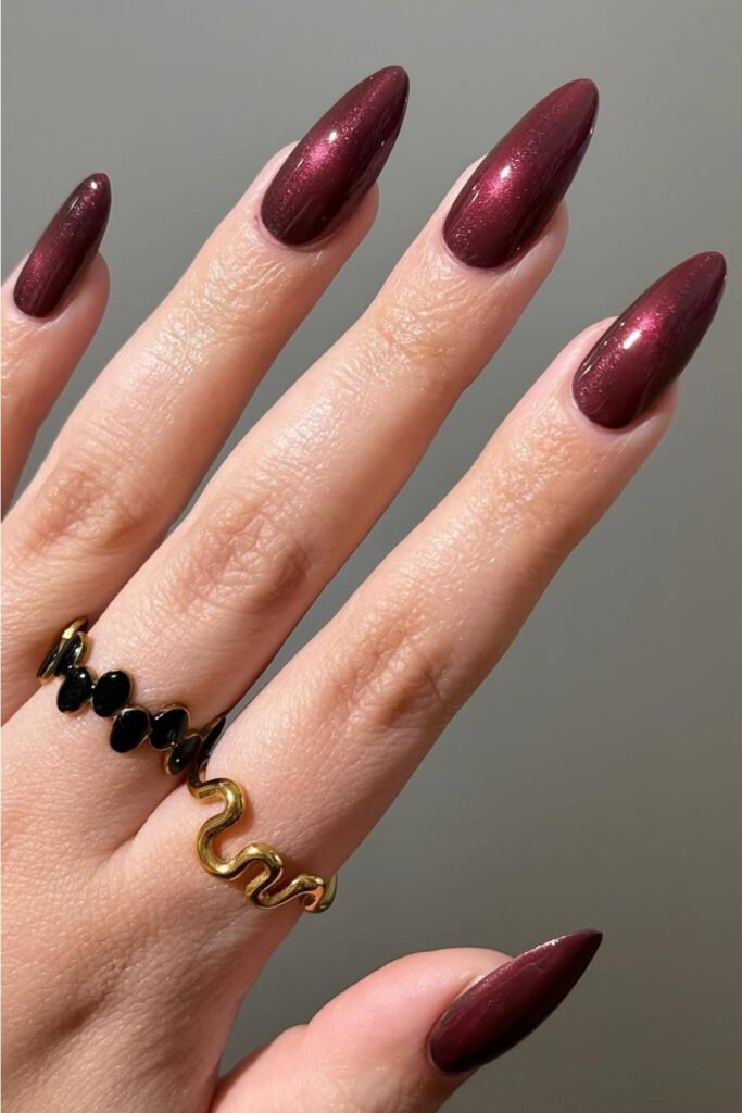 Glossy dark cherry mocha almond nails with a black ring