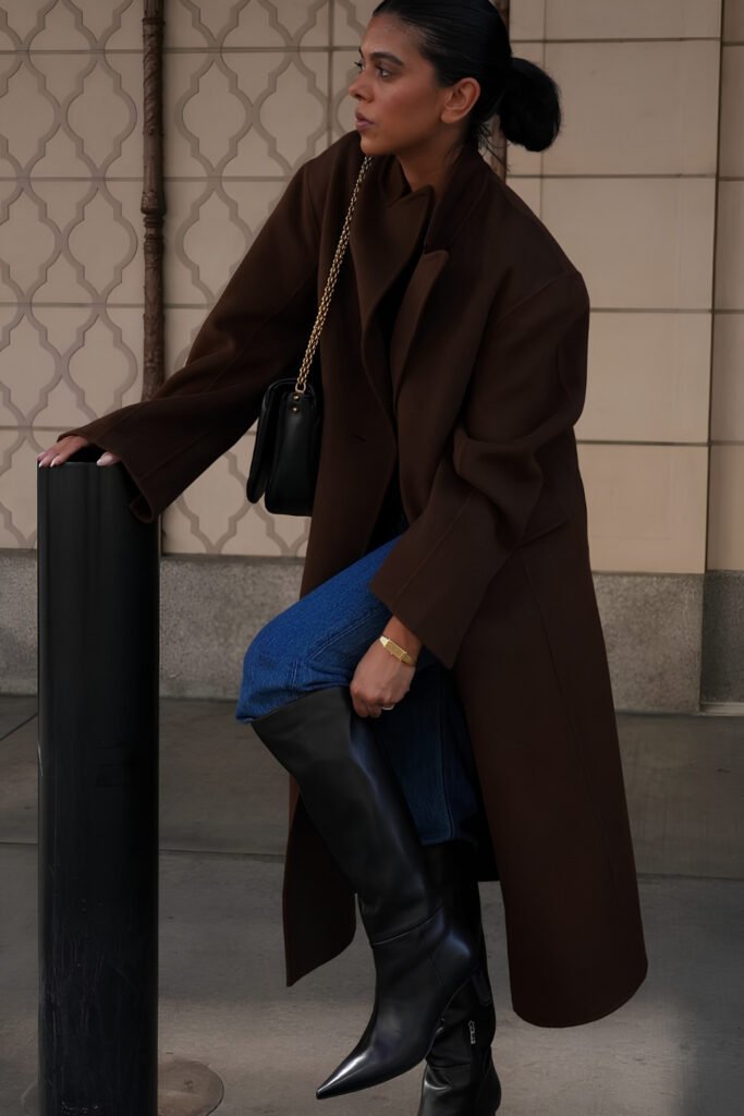 Woman in a long dark wool coat with knee-high boots