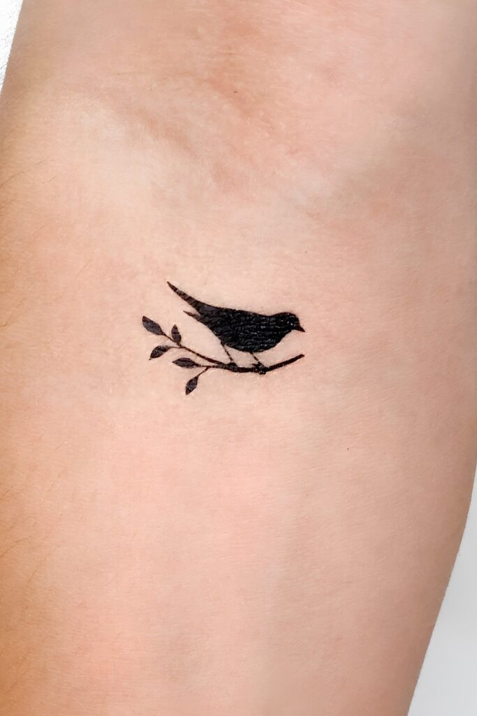 Mini sparrow silhouette tattoo on a man