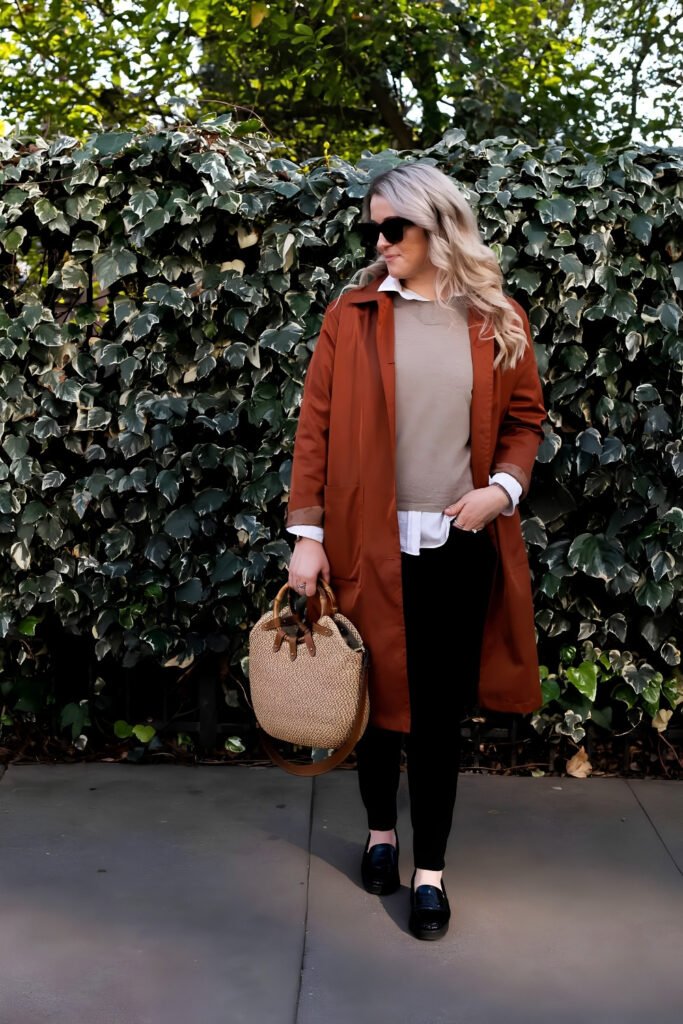 Woman in a long rust coat with black trousers