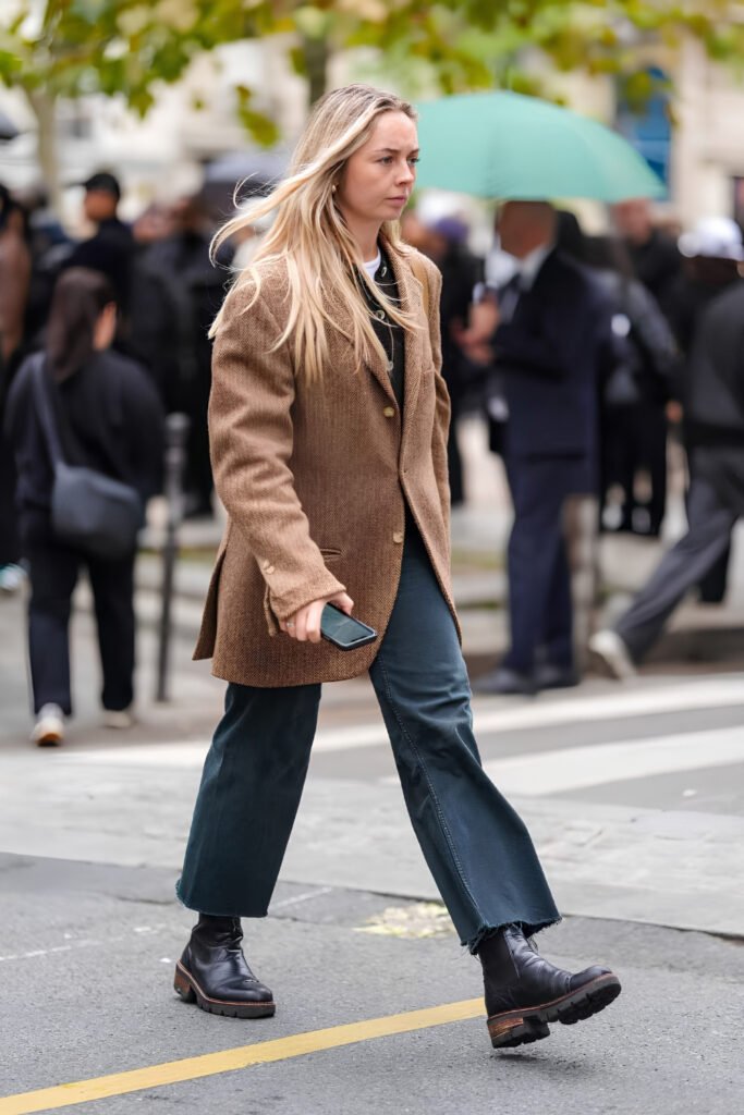 Woman in a camel coat and cropped trousers walking through the Old Town