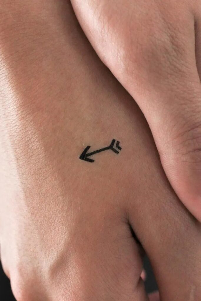 Tiny arrow tattoo on a man