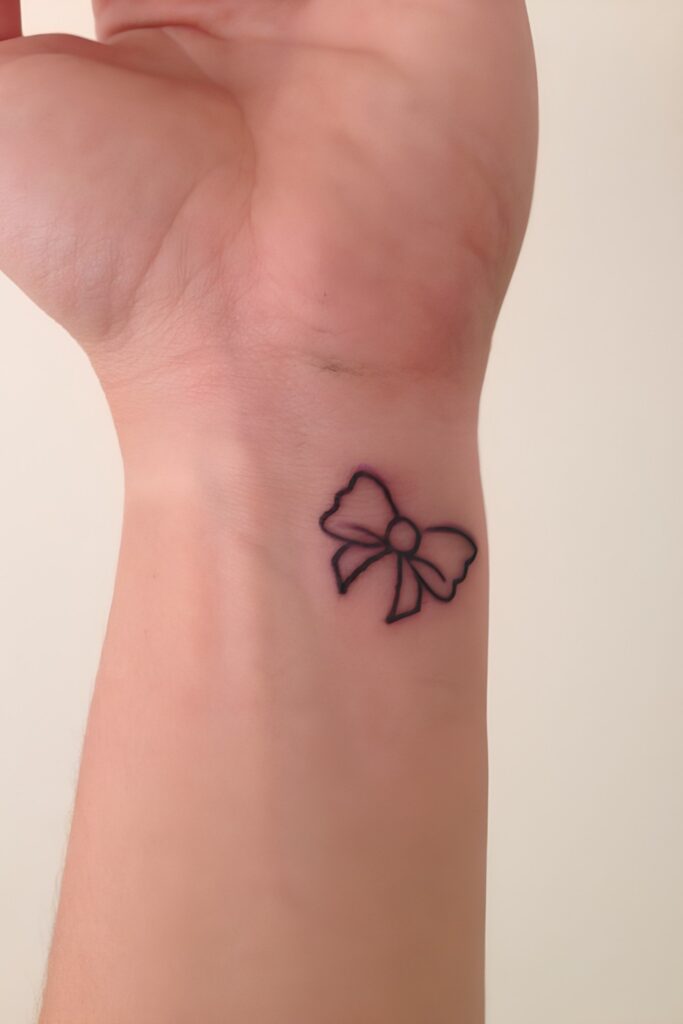 Tiny bow tattoo on a man