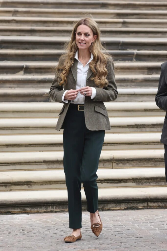 Woman in a tweed blazer with tailored trousers on stone steps