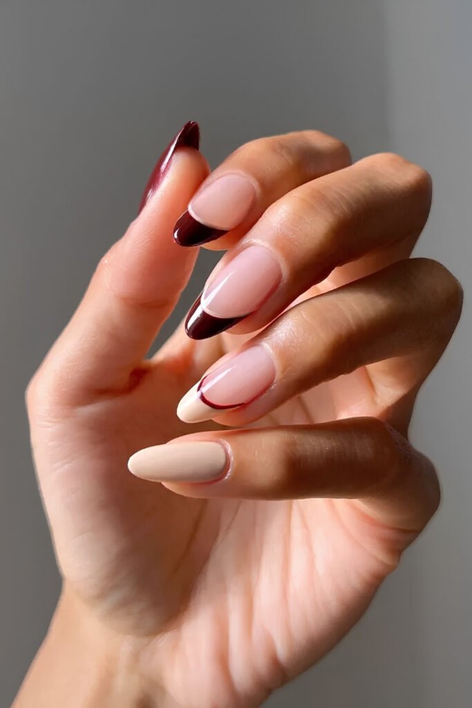 Almond nails in creamy nude with dark cherry mocha accents