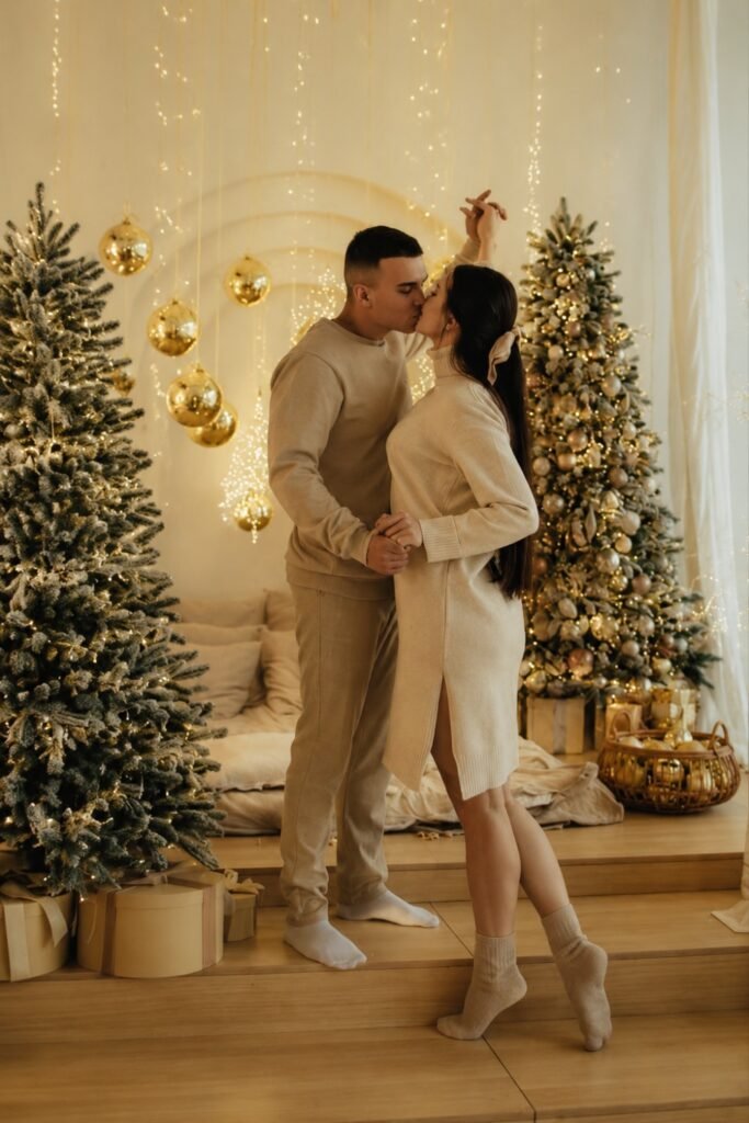 Couple in cream and beige outfits beside a Christmas tree