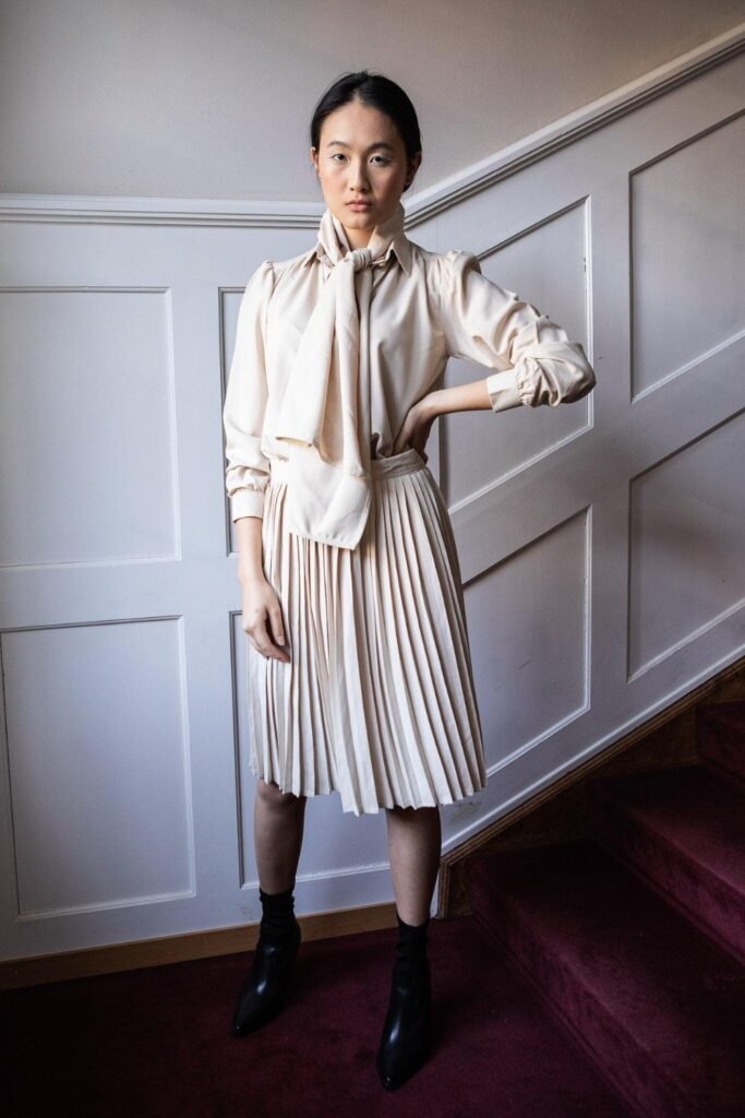 Kitten-heel Chelsea boots with a pleated midi skirt and silk blouse