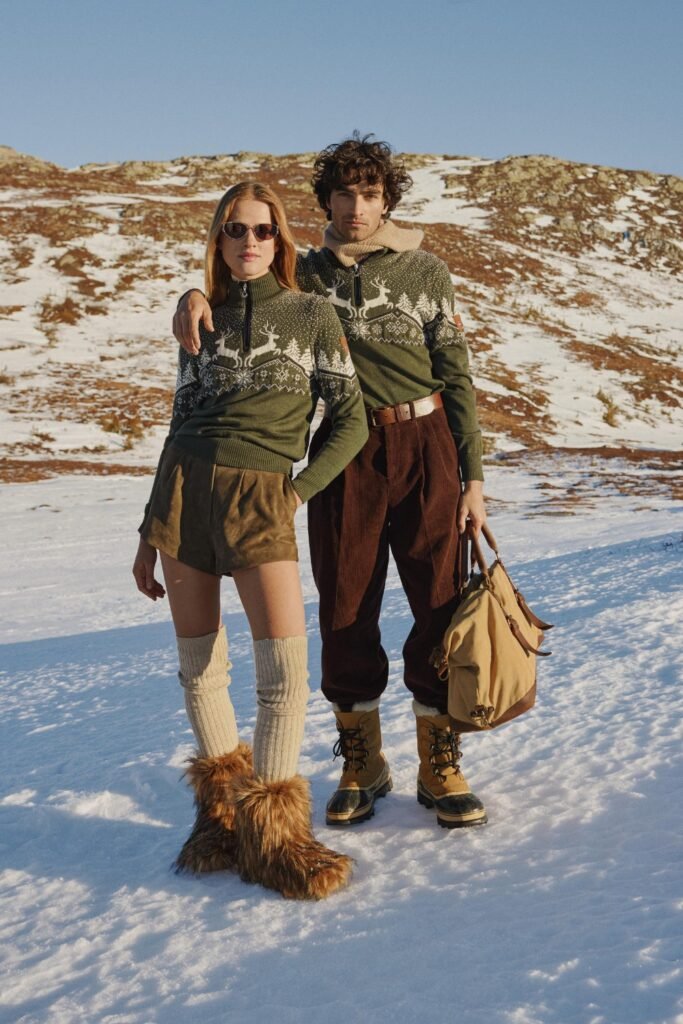 Couple in Christmas jumpers standing in the snow