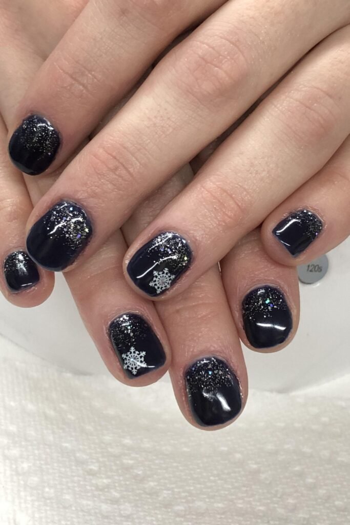 Short navy nails with small white snowflakes