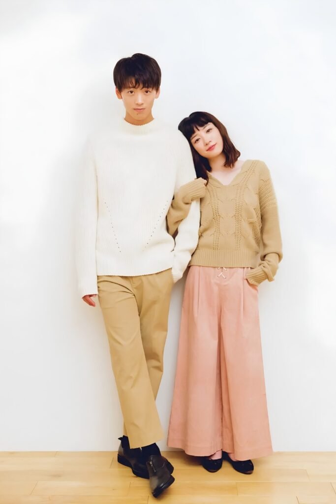 Couple in a cream knit and dusty rose trousers