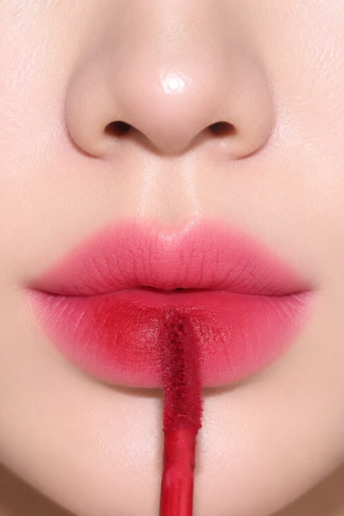 Close-up of a rose gradient lip with a tint applicator