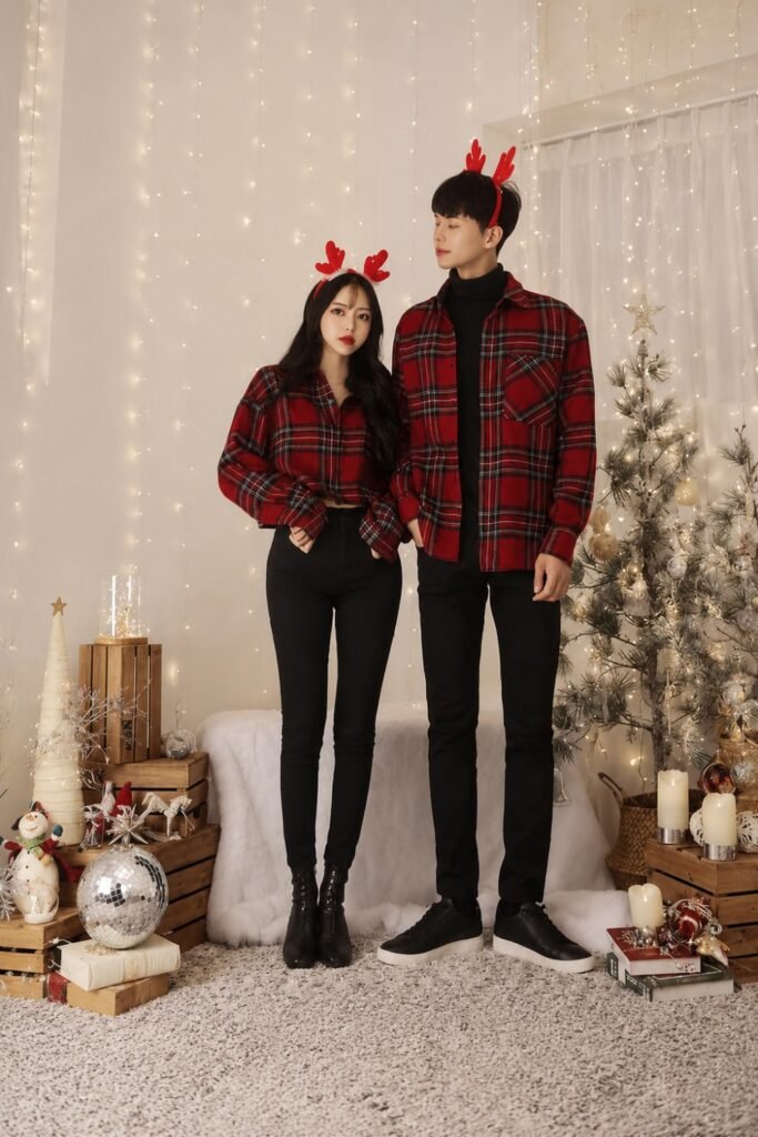 Couple in red plaid flannel and dark denim wearing reindeer antlers