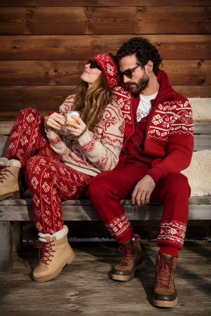 Couple in red Nordic knit sets on a ski lodge porch