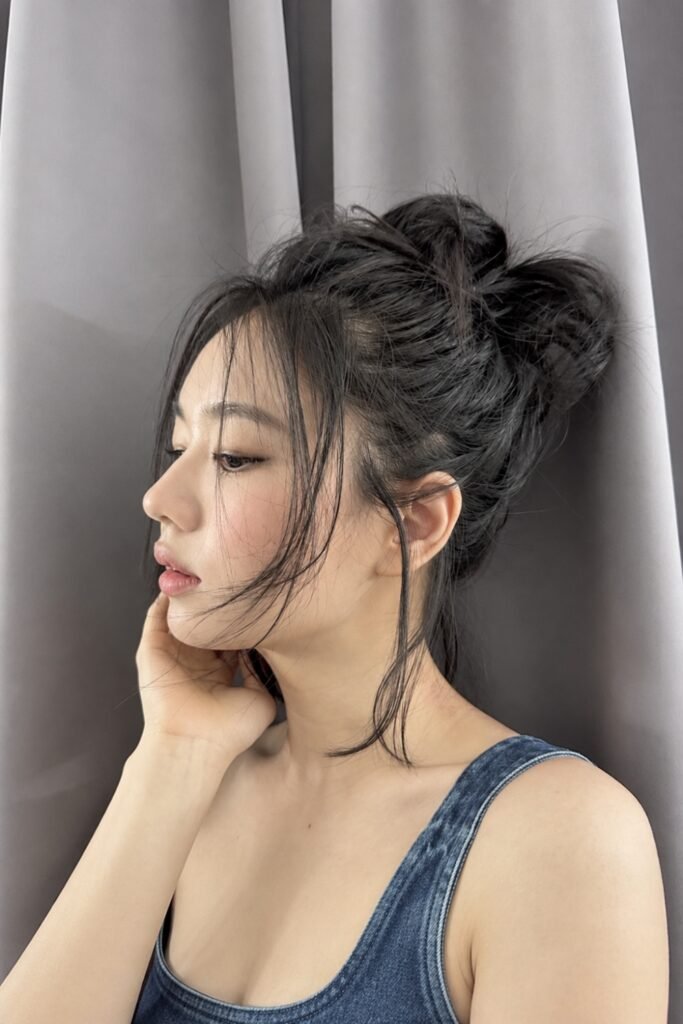 Airy messy bun with loose face-framing strands, side view