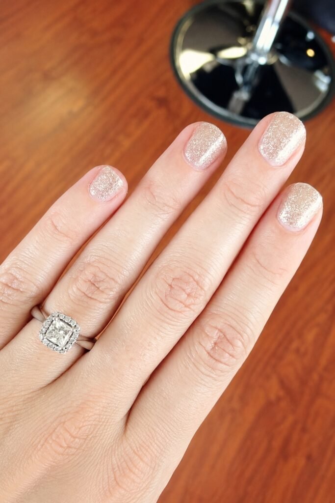 Short nails with champagne shimmer and a diamond ring