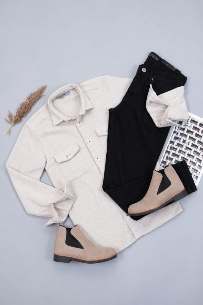 Flat lay of a cream flannel shirt, black jeans and Chelsea boots